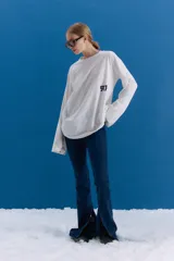 Jean de tiro medio-alto en color azul, con corte oxford y botamanga ancha con tajo frontal. Presenta cierre frontal con cinco botones metálicos visibles.