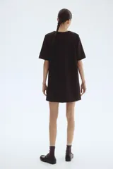 Vestido corto negro de manga corta y corte recto, con escote en V pronunciado en la parte delantera.