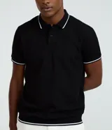 Remera polo blanca de viscosa texturizada con rayas, cuello y puños de mangas cortas en ribana con detalles contrastantes en negro.