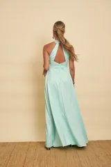 Vestido largo de satén color celeste menta, con escote halter cruzado y falda fluida con abertura frontal.