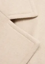 Abrigo largo de lana italiana Manteco en color beige, con diseño envolvente, cuello con solapas y cinturón ajustable a la cintura. Presenta mangas largas con trabillas en los puños y bolsillos laterales.