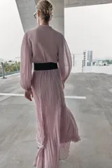 Vestido midi de color rosado con escote en pico y mangas largas. Presenta un diseño combinado con paneles de encaje en el frente y cierre frontal con botones forrados. Incluye un cinturón de cuero sintético marrón con hebilla metálica dorada.