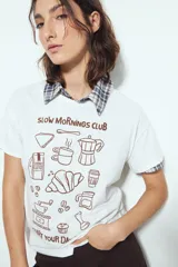 Remera negra de manga corta con estampado frontal en color marrón que incluye ilustraciones relacionadas con el café y la frase "Start Your Day Right".