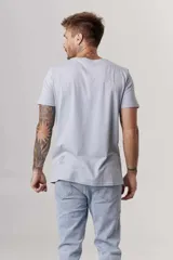 Remera blanca de manga corta con cuello redondo y un pequeño estampado azul en el pecho.