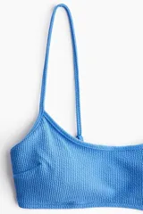 Top de bikini azul con textura acanalada y tirantes finos.