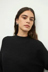 Polera marrón de tejido tramado, cuello alto y mangas largas acampanadas.