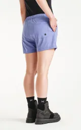 Short de baño de calce regular, color lavanda, con cintura elástica ajustable mediante cordón negro. Posee bolsillos laterales y un pequeño parche negro con un logo de tijeras cruzadas en la parte inferior frontal.