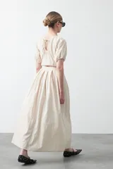 Falda larga plisada color marrón, de silueta amplia y caída fluida.