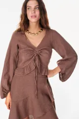 Top de lino italiano color beige, con escote en V, mangas abullonadas y cordón ajustable en el centro del frente.