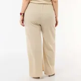 Pantalón ancho de tiro alto confeccionado en punto crepé color beige, con diseño de perneras holgadas y rectas.