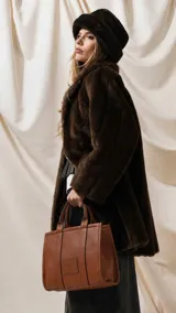Cartera estructurada de tamaño mediano, confeccionada en símil cuero color negro. Presenta doble asa de mano, correa larga ajustable y desmontable, y un bolsillo trasero con cierre. El compartimento principal cuenta con cierre, división interna y bolsillos organizadores.