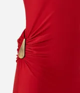 Vestido midi sin mangas color rojo, confeccionado en microfibra con elastano. Presenta un diseño drapeado en el lateral de la cintura con un adorno metálico en forma de gota, escote redondo y una abertura lateral en la falda.
