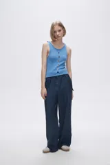 Musculosa verde melange de tejido de punto con tres aberturas circulares en el frente.