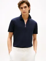 Chomba azul marino de corte regular con cuello tipo chomba y cierre de cremallera de 1/4 con cinta distintiva. Logo de Tommy Hilfiger bordado en la manga.