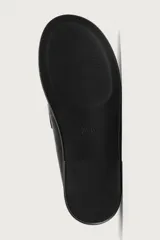 Mocasines destalonados de cuero color negro, de diseño liso con detalle de antifaz en el empeine y horma redonda.