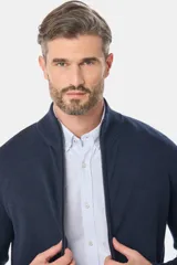 Campera tejida de algodón azul con cierre frontal y cuello alto. Corte clásico.