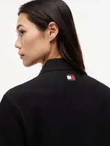 Chomba de algodón elástico con cuello polo y cartera de tres botones. Presenta un diseño de corte regular con cuello y puños de punto canalé, destacando por el logo colaborativo de Tommy Hilfiger y Cadillac Formula 1 en el pecho.