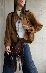 Campera tipo bomber de gamuza color camel, con diseño de doble botonadura frontal, cuello camisero y mangas largas con puños abotonados.