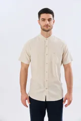 Camisa de lino y algodón de manga corta, color negro, con cuello mao, cierre frontal con botones y bolsillo ojal en el pecho.