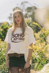 Remerón de algodón color crudo con estampado marrón que dice 'SOHO NY 1985'.