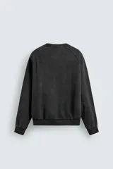 Sudadera de corte relaxed fit confeccionada en tejido de algodón con interior de rizo. Presenta cuello redondo, manga larga y acabados en rib, con un acabado de efecto lavado que le otorga una apariencia única.