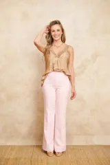 Musculosa de seda color dorado, con escote en V adornado con detalles de encaje y tirantes finos.