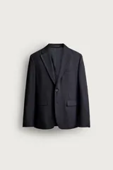 Blazer de corte relaxed fit confeccionado en tejido con lana, con solapas de muesca, manga larga con botones en los puños, bolsillos con solapa en la cadera, un bolsillo de vivo en el pecho y cierre frontal con dos botones.