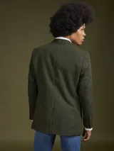Blazer de corte clásico en color verde oliva con textura jaspeada. Presenta solapas de muesca y cierre frontal con botones.