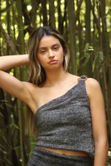 Top tejido con lurex plateado, de un solo hombro y hebilla circular en la tira.