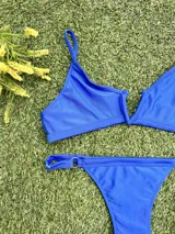Conjunto de bikini azul eléctrico, con corpiño triangular con escote en V y bombacha colaless regulable.