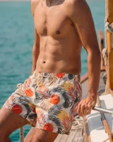 Short de baño Albania Trunk de secado rápido, con estampado tropical de hojas y círculos naranjas sobre fondo blanco, cintura elástica con cordón ajustable y tres bolsillos.