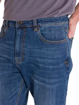 Jeans de denim azul con calce slim, diseño clásico de cinco bolsillos, cierre de cremallera y botón, y costuras en contraste.