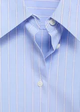 Camisa de rayas celestes y blancas, de manga larga con puños abotonados, corte recto, cuello camisero y cierre delantero con botones.