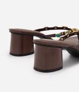Sandalia de taco bloque Satinato, color marrón, estilo thong con tira de dedo decorada con apliques de piedras de resina y metales dorados.