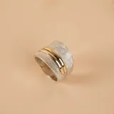 Anillo de diseño ancho con acabado satinado en plata 925, que presenta una banda central lisa en oro, creando un contraste elegante y moderno.
