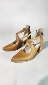 Sandalias de cuero 100% natural color tostado, con diseño de tiras cruzadas en el empeine, punta fina y taco cuadrado de madera con acabado rústico.