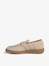 Mocasines Adidas Handball Spezial confeccionados en gamuza color beige, con diseño inspirado en el calzado deportivo clásico. Presentan las icónicas tres bandas laterales, una tira frontal con detalle de logo dorado y suela de goma color caramelo.