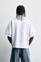 Camisa de manga corta confeccionada en tejido de cáñamo, con calce relajado. Presenta cuello solapa, cierre frontal con botones y dos bolsillos de plastrón en la parte inferior delantera.