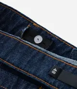 Bermuda tipo jorts de corte amplio y tiro medio, confeccionada en denim de algodón azul oscuro. Presenta diseño de cinco bolsillos, cierre frontal con botón y costuras en tono contrastante.