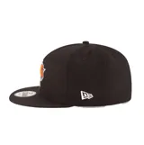 Gorra New Era modelo 9Fifty de los New York Knicks, color negro con visera plana y diseño estructurado. Cuenta con el logo bordado del equipo en el frente en relieve y el logotipo de New Era bordado en el lateral.
