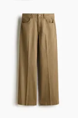 Pantalón tobillero de corte bootcut en lona de algodón, color marrón, con cintura estándar, bolsillos delanteros y pliegues marcados.