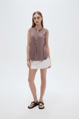 Blusa evasé de viscosa color blanco, sin mangas, con cuello a la base y escote en V con cartera frontal.
