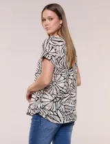 Blusa de silueta holgada y recta, confeccionada en crepe de poliéster con estampado animal print. Presenta escote redondo clásico, mangas cortas de hombro caído con puño doblado y ruedo ligeramente curvo.