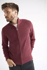 Campera tejida de algodón en color bordó, con cierre frontal completo, cuello levemente elevado y textura acanalada. Presenta puños y ruedo elásticos.