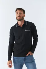 Polo de manga larga negra con cuello clásico, tapeta de dos botones y bolsillo de parche en el pecho con ribete blanco. Logo de la marca bordado en blanco sobre el bolsillo.