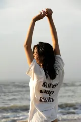 Remera oversize blanca con estampado en la espalda que dice "Sunset Clap Club uruguayan members only".