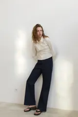 Camisa entallada de cuello solapa y manga larga con puños. Presenta un diseño de doble botonadura frontal y un bolsillo lateral en el pecho.