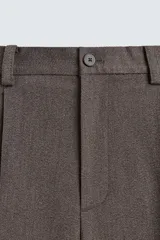 Pantalón de traje wide fit color marrón oscuro con textura, pinzas frontales, bolsillos laterales y cierre con cremallera y botón.