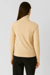 Polera de tejido de punto color blanco, con cuello redondo y manga larga.