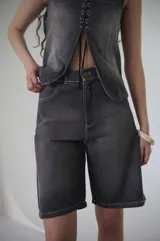 Bermuda de denim azul claro, de tiro medio y largo a la rodilla, con calce relajado y silueta amplia. Cuenta con bolsillos delanteros y traseros, y cierre frontal con botón y cremallera.